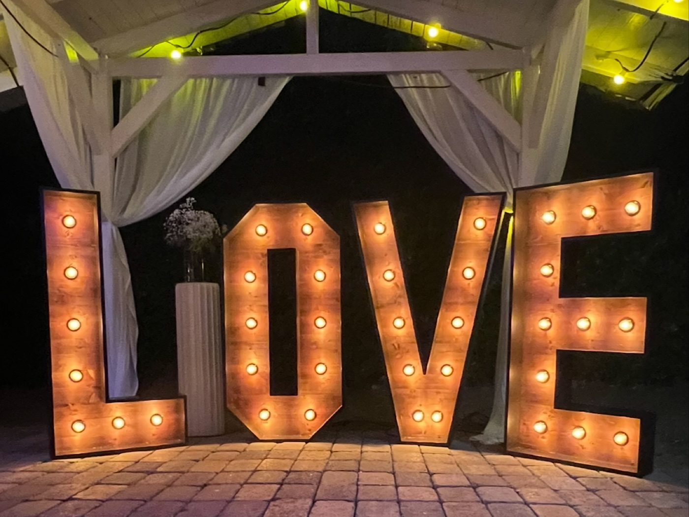 LOVE Buchstaben mieten Bochum – leuchtende LOVE-Buchstaben aus Holz vor einem Pavillon mit Lichterketten